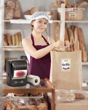 In bakery, staff in apron bags bread. Ndyin label maker prints “BAKED FRESH DAILY” label; bag has “mimi homemade” sticker., promising freshness and quality to customers.